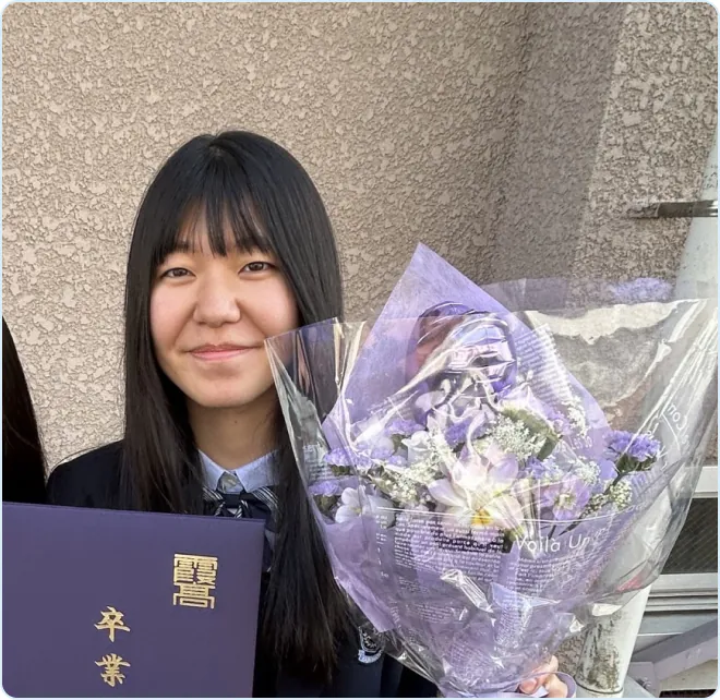 卒業証書と花束を手にする関戸さん